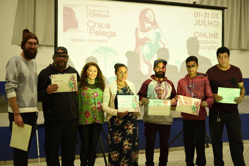 Participantes recebem certificados da oficina de cinema diante da arte da 3ª Mostra Chica Pelega — edição quilombola